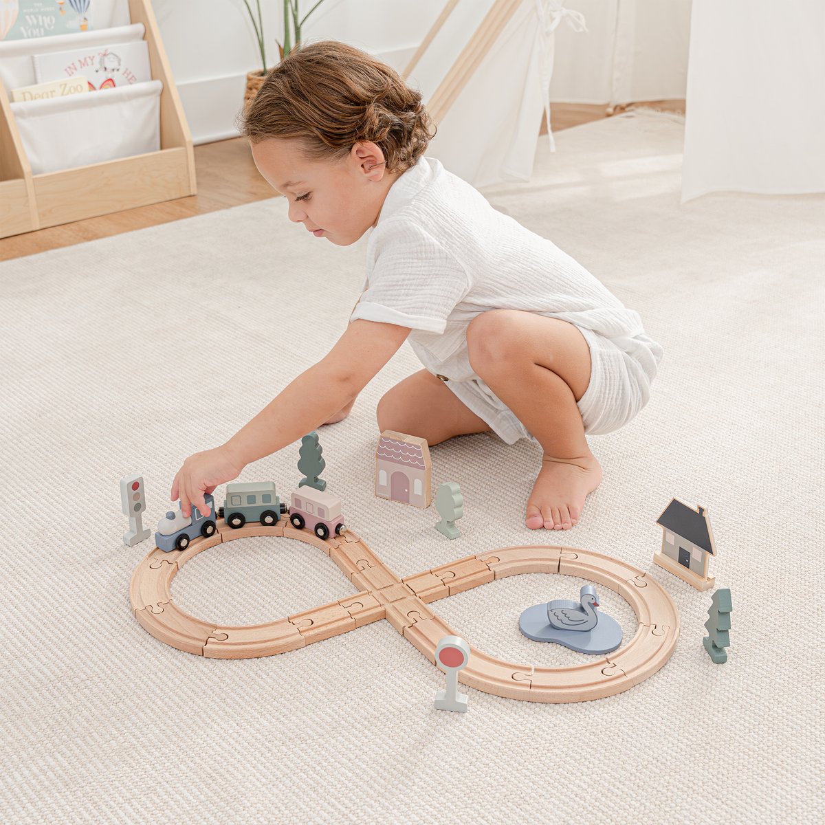 Toddler playing with a pastel wooden train and track