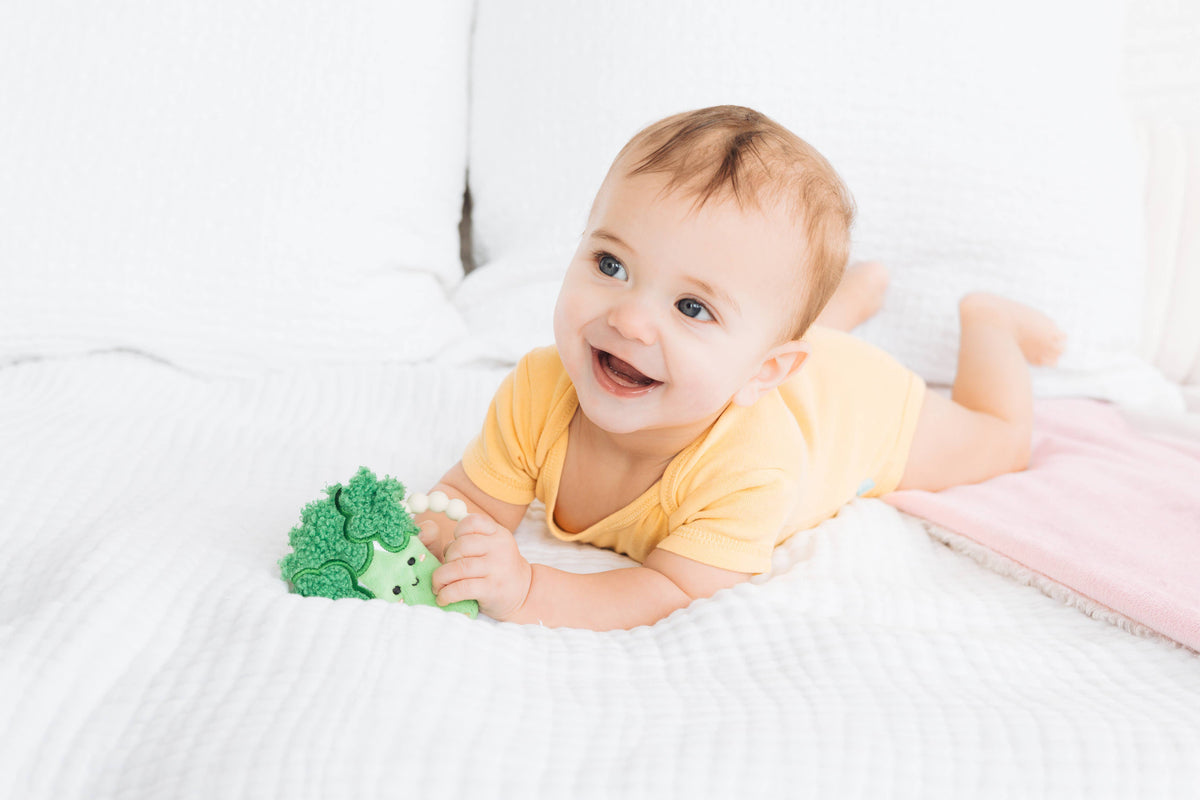 Broccoli crinkle and silicone ring teether, baby lying