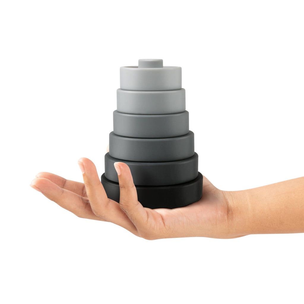 Fred & Friends Buff Baby weight plate stacker and teether, stacked, shown in a hand for scale