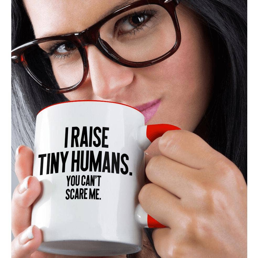 Woman drinking from the I Raise Tiny Humans mug