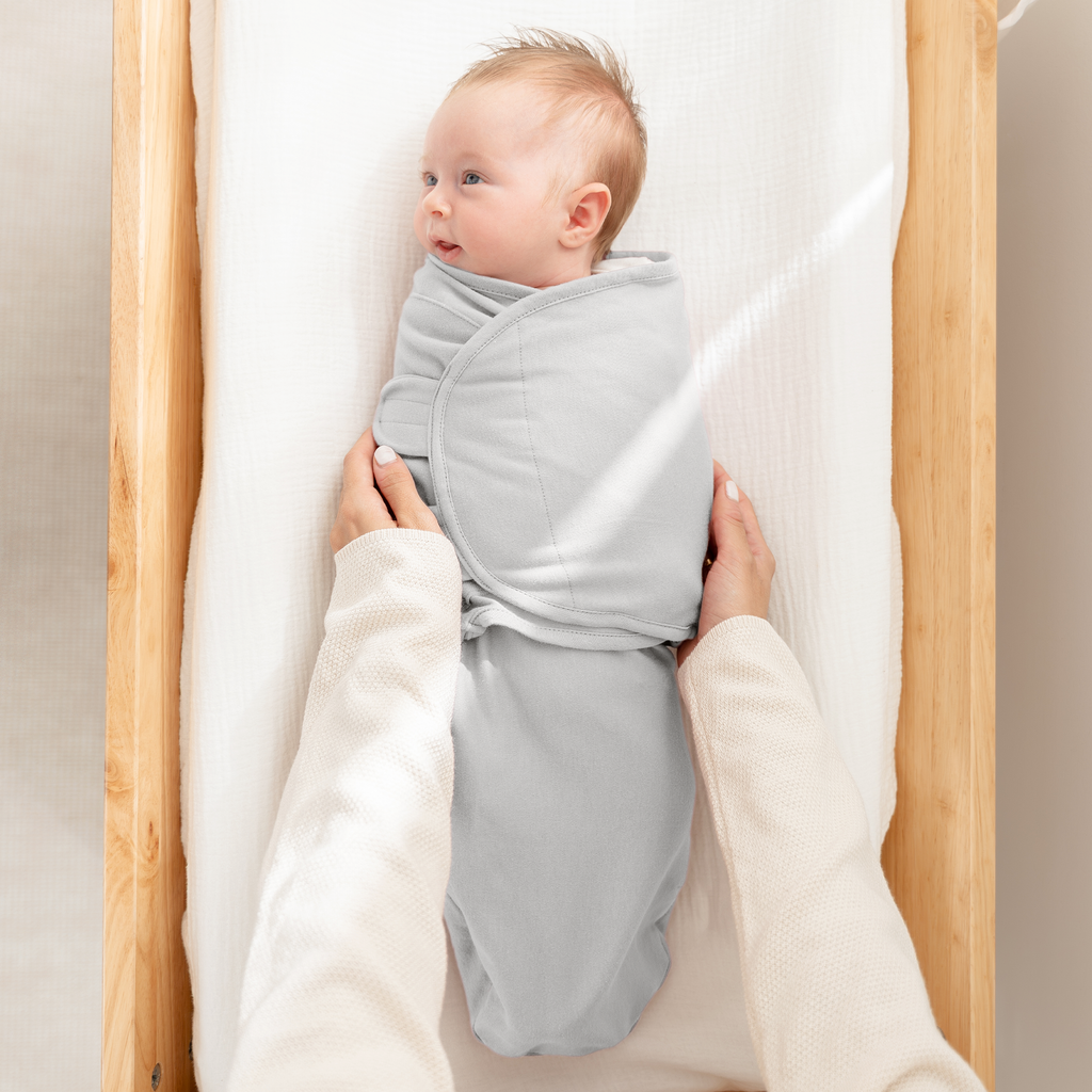 Newborn sleeping in a grey easy swaddle