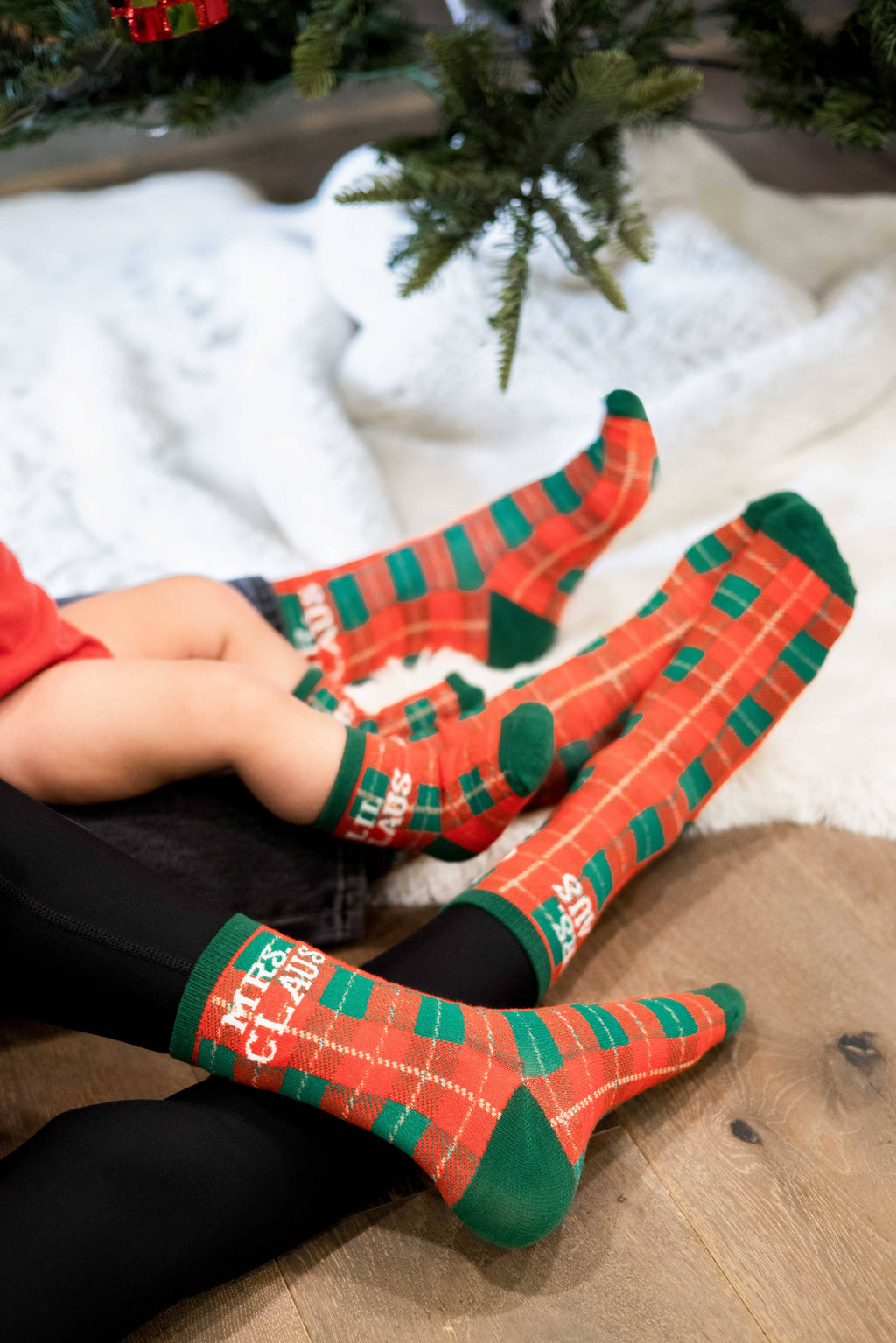 Red and green plaid family Christmas sock set, close-up of the socks on feet