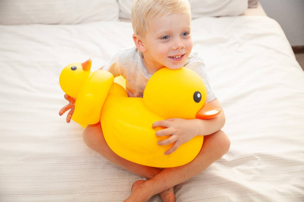 Child cuddling the oversized yellow rubber duck