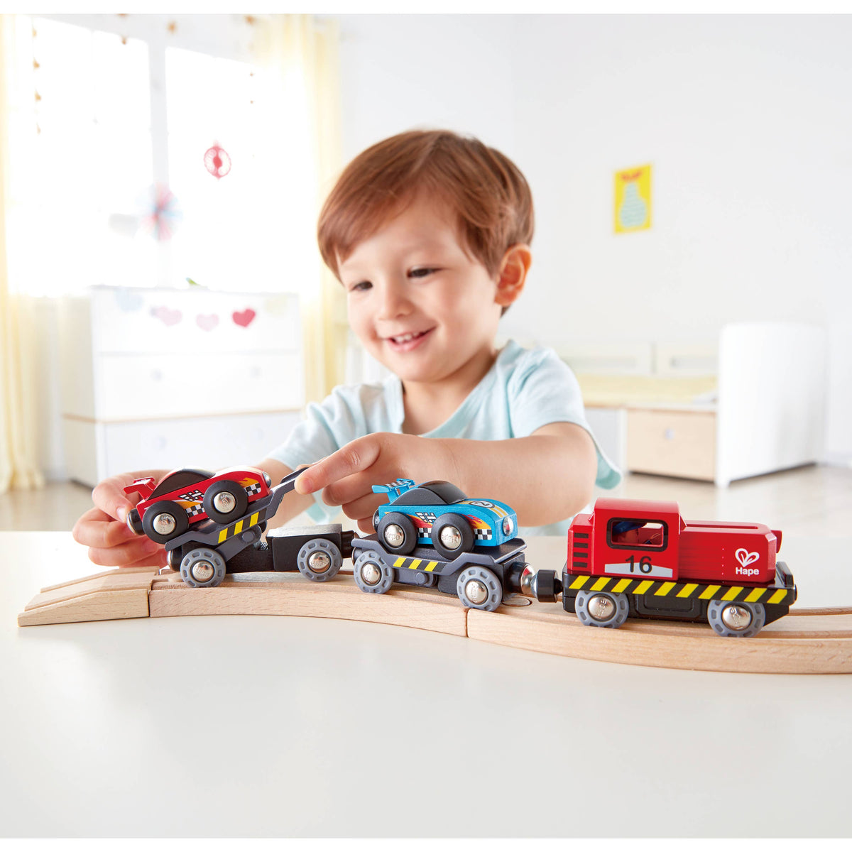 Boy playing with the Hape Race Car Transporter