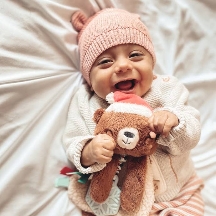 Itzy Ritzy reindeer sensory lovey with teether, held by baby