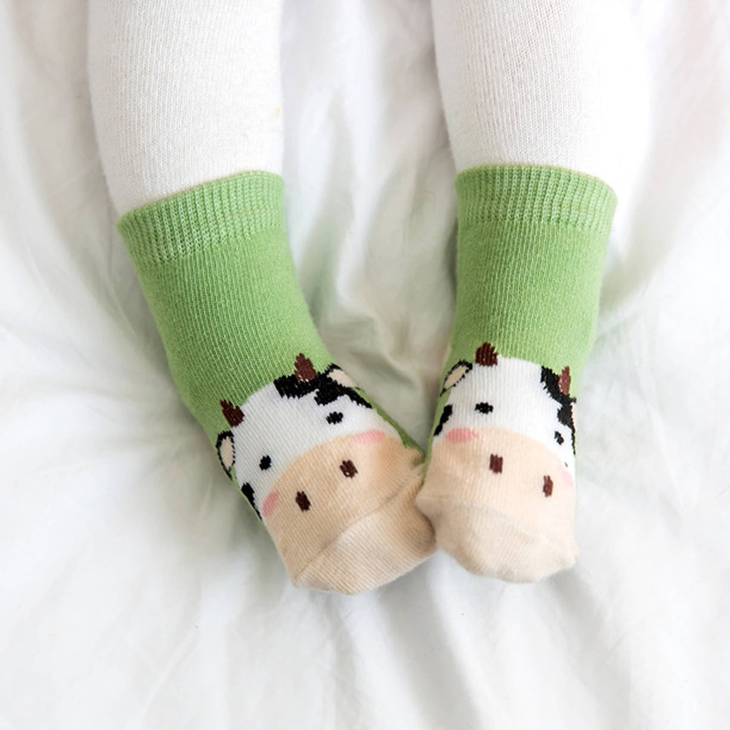 Baby wearing green cow grip ankle socks
