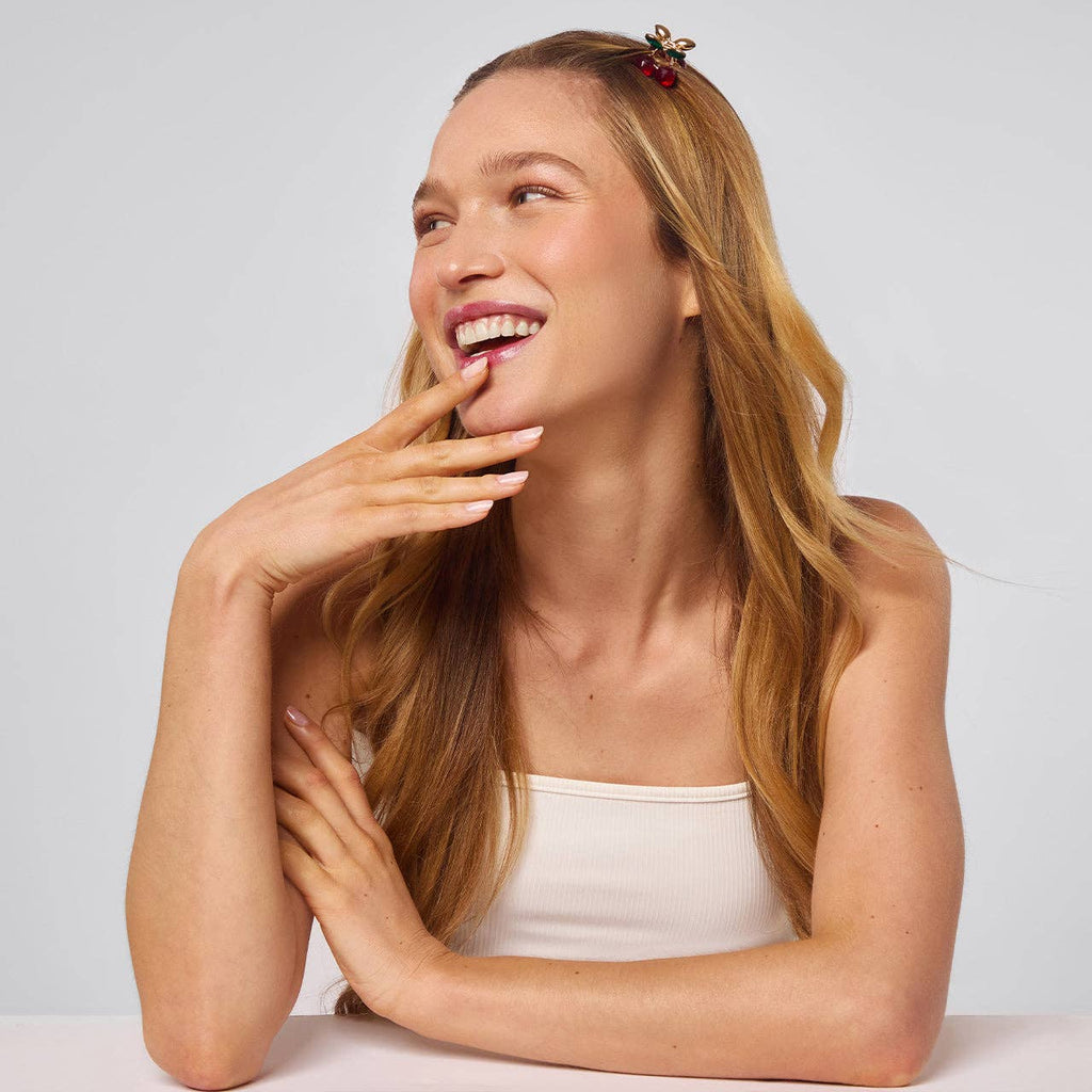 Kitsch cherry rhinestone mini claw clips, worn by a smiling woman