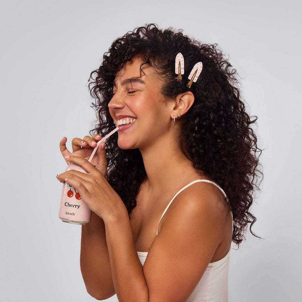 Kitsch cherry print creaseless hair clips, worn by a smiling woman
