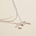 Layered silver necklace with lock, key and heart charms, charm detail