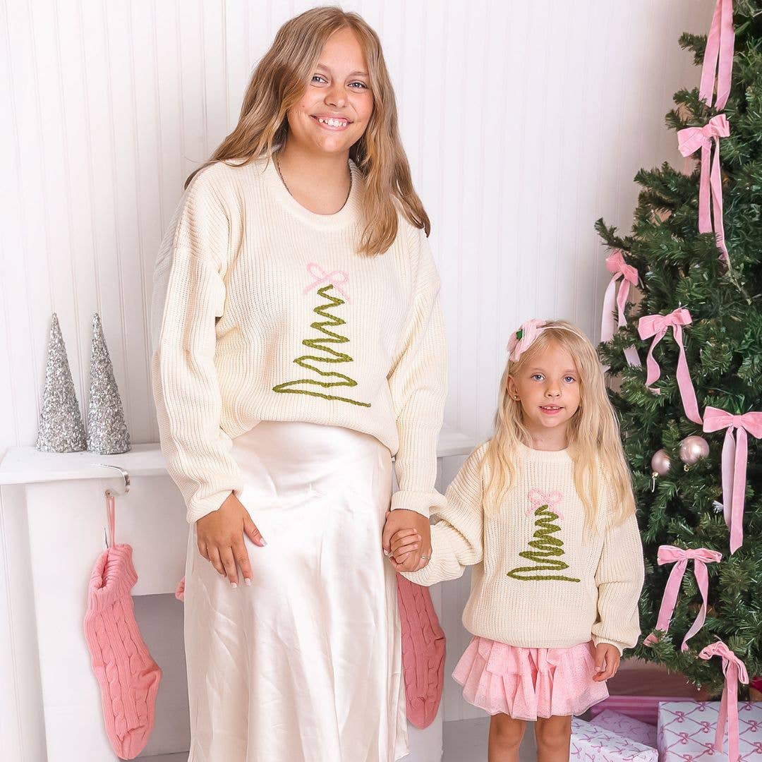 Two girls in matching Christmas tree sweaters