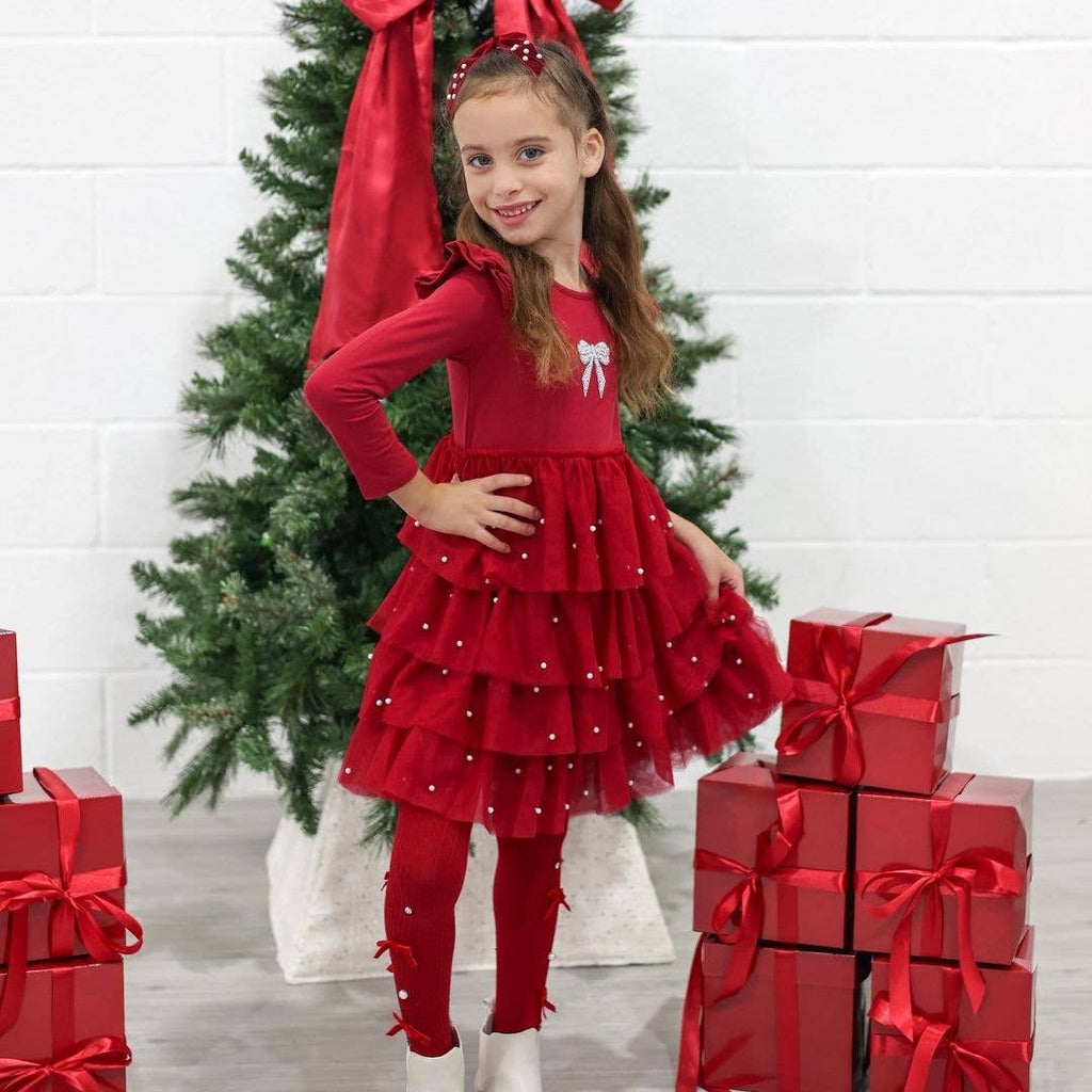 Girl in the red layered tulle dress by the Christmas tree