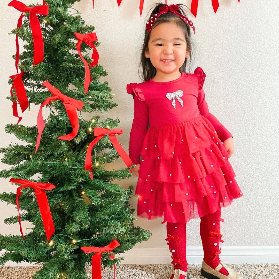 Girl in the red tulle dress by the tree