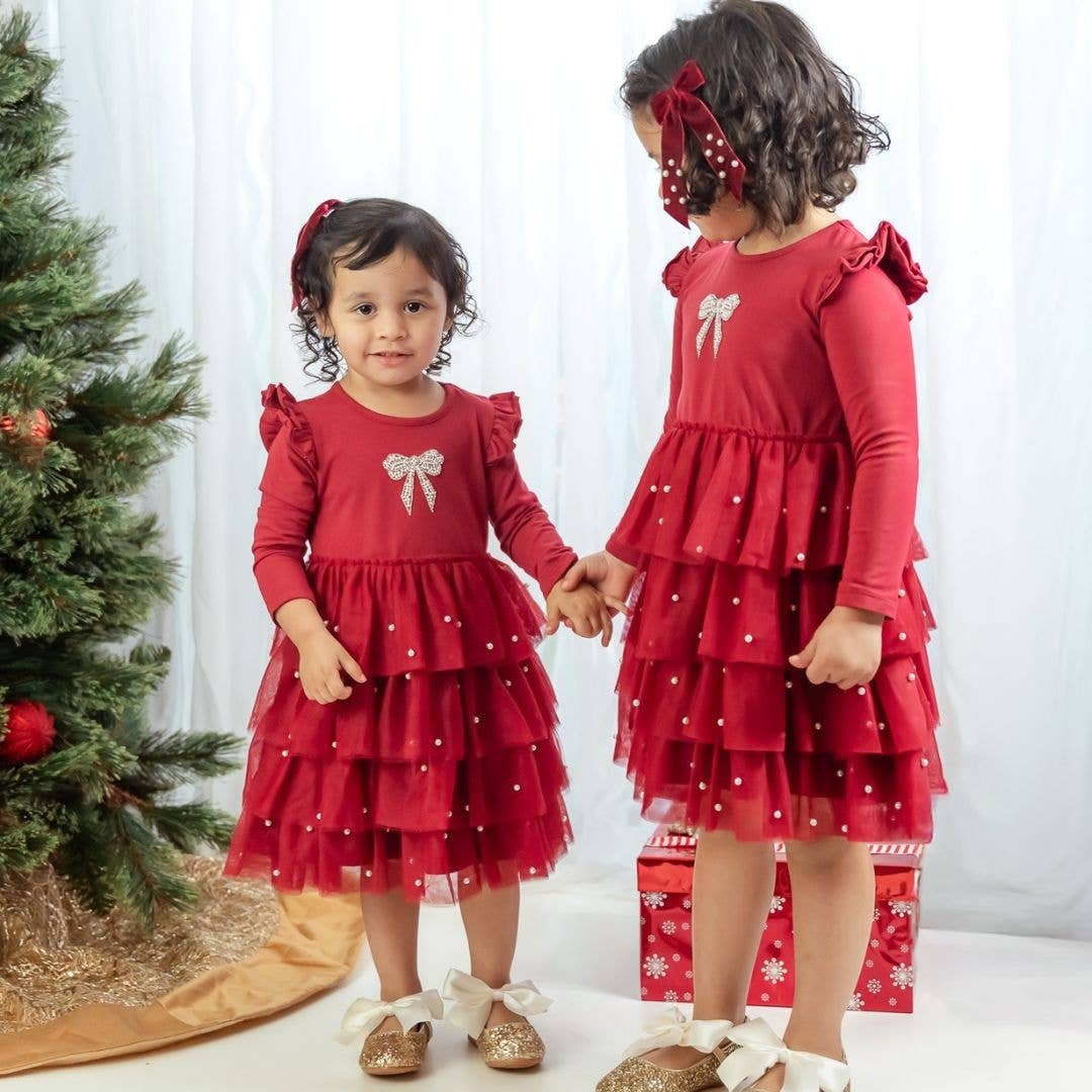 Two girls in matching red tulle holiday dresses