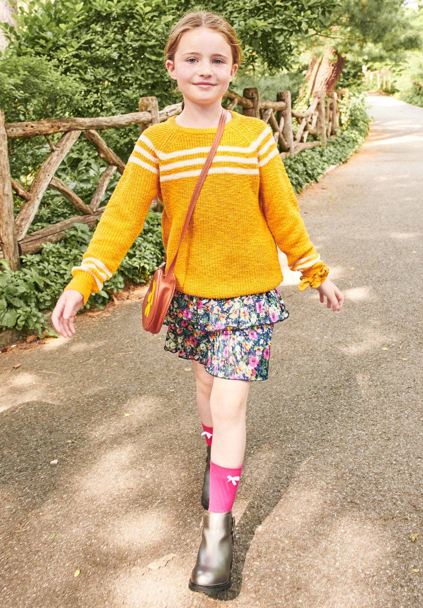 Girl wearing the tiered floral skirt with a yellow sweater