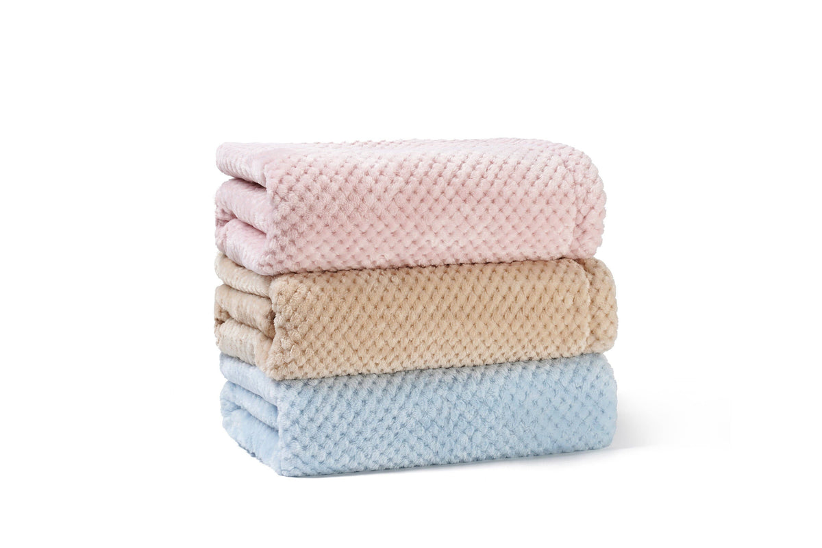 Pink, beige and blue minky baby blankets folded in a stack