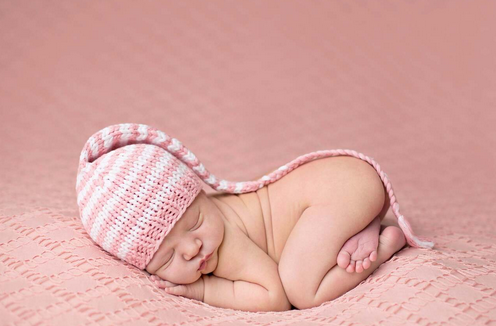 Newborn knit striped braided hat, pink and white, worn by baby