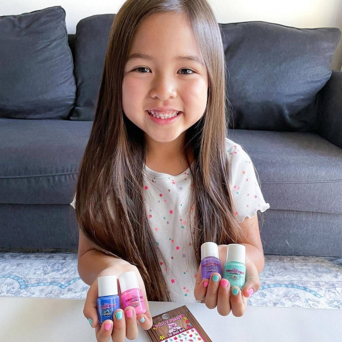 Smiling girl holding polish bottles