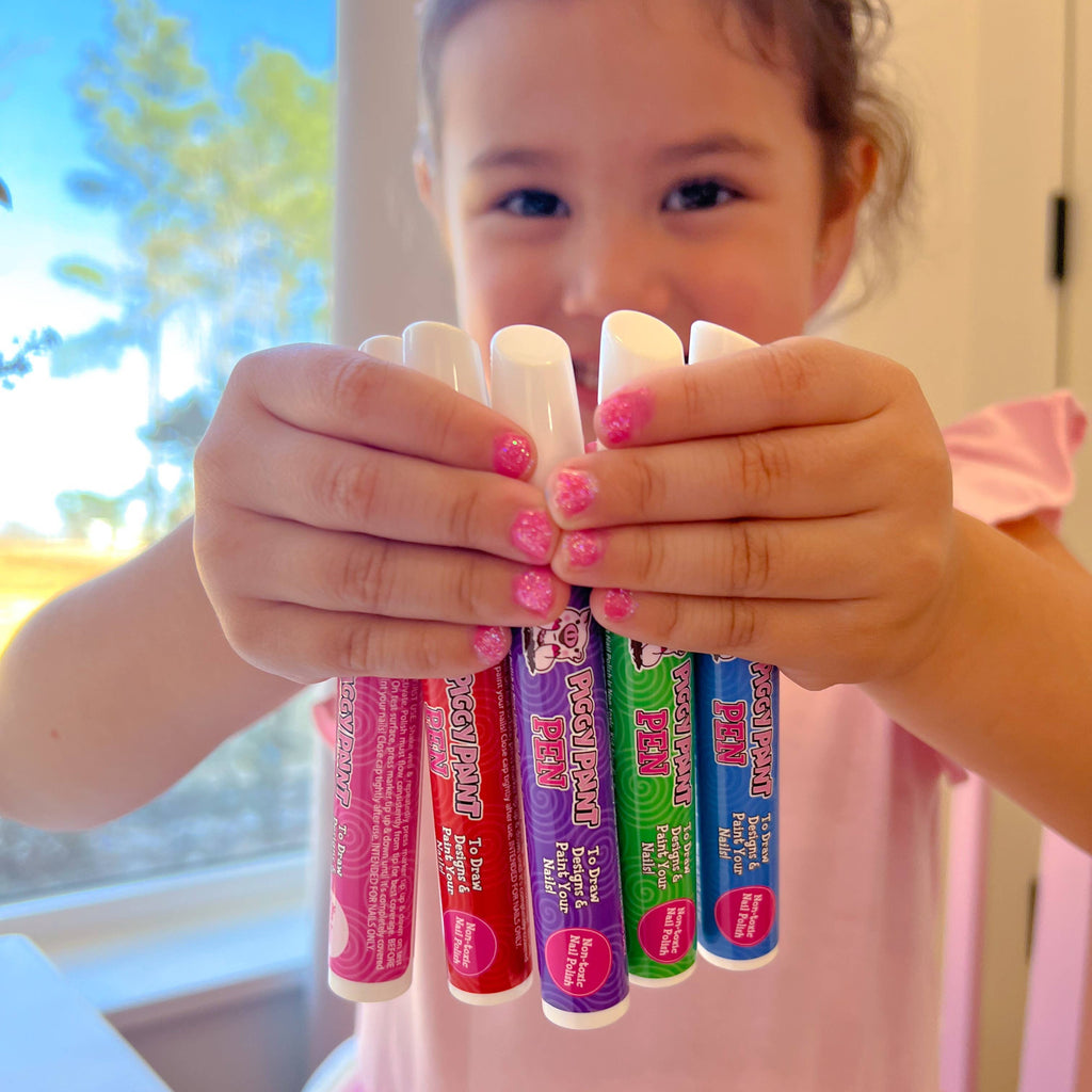 Girl holding Piggy Paint nail polish pens