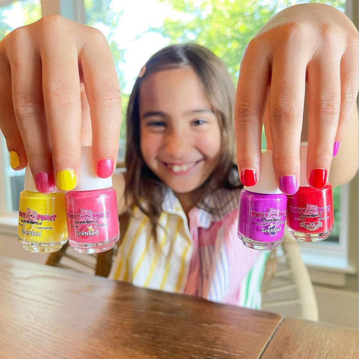 Girl holding Piggy Paint polish bottles