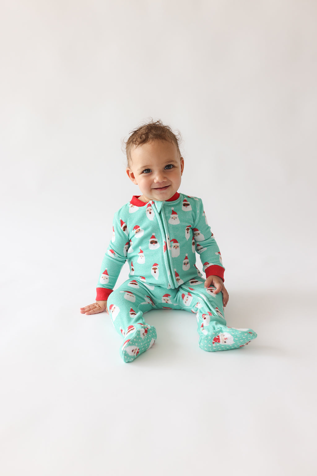 Posh Peanut Pacci fleece zip footie, Santa medley, worn by baby