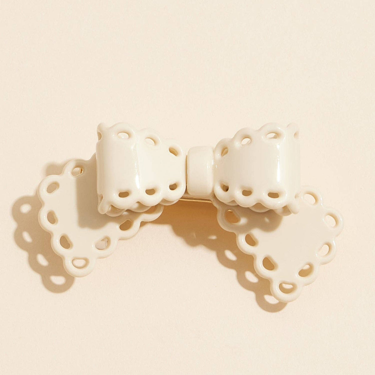 Scalloped lace cutout bow hair clip, ivory, front view