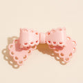Scalloped lace cutout bow hair clip, pink, front view