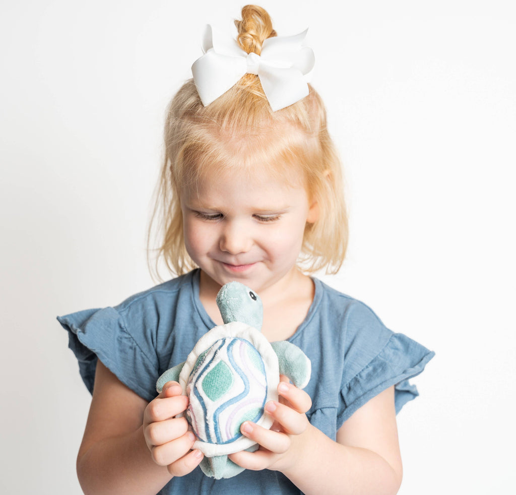 Tooth fairy pocket plush, sea turtle, held by child