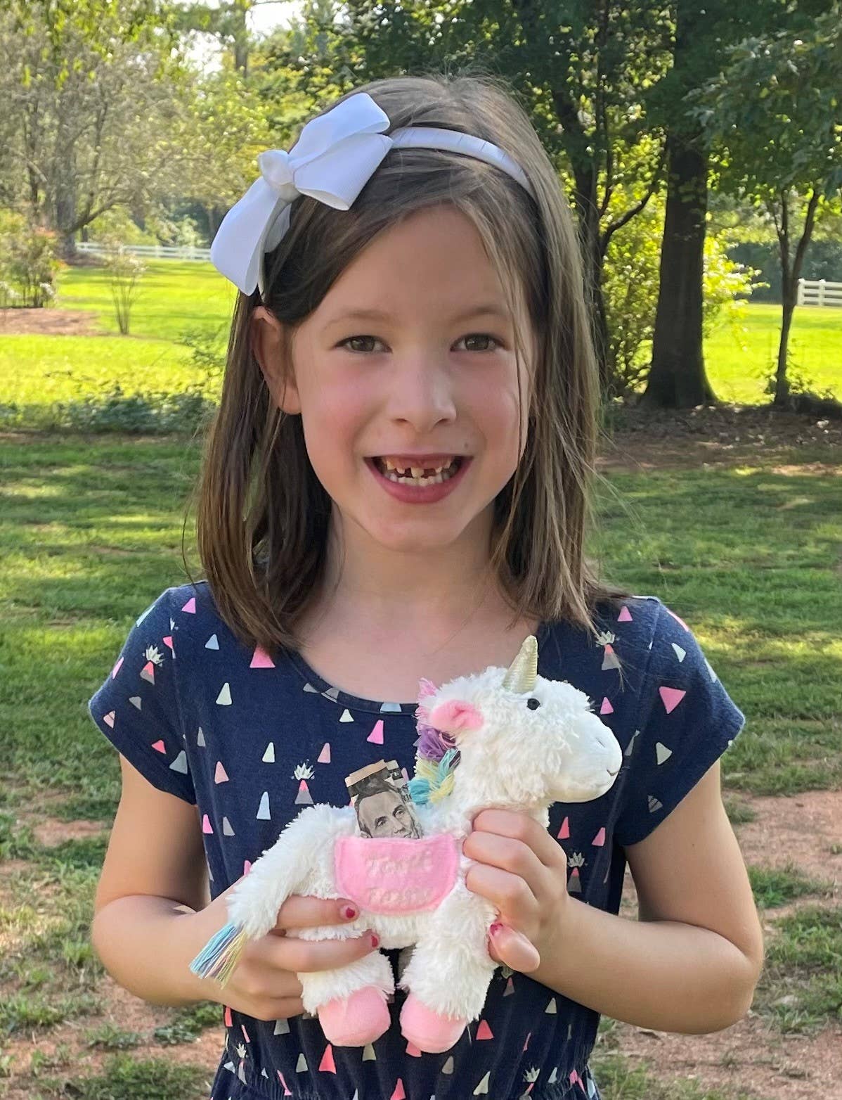 Tooth fairy pocket plush, trixie the unicorn, held by child