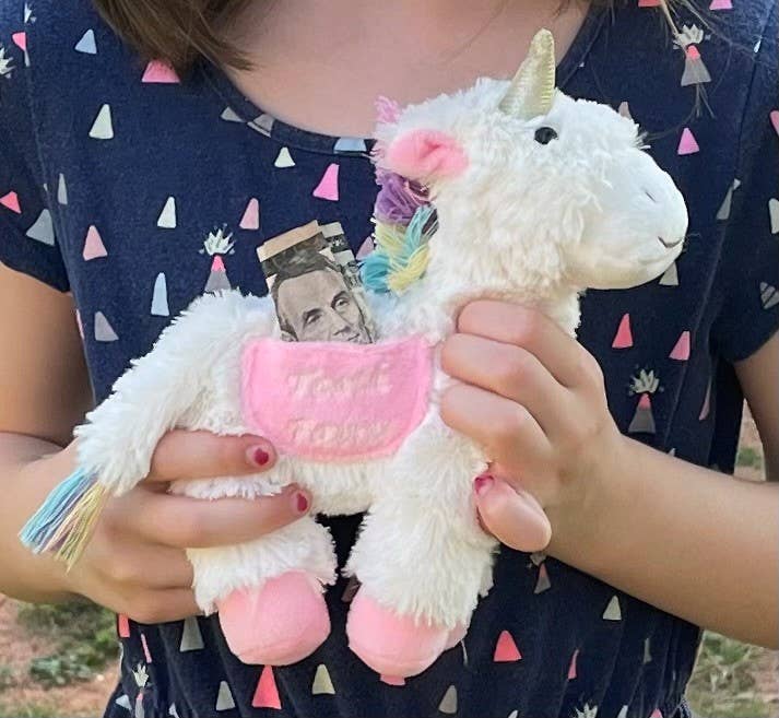 Tooth fairy pocket plush, trixie the unicorn, held by child