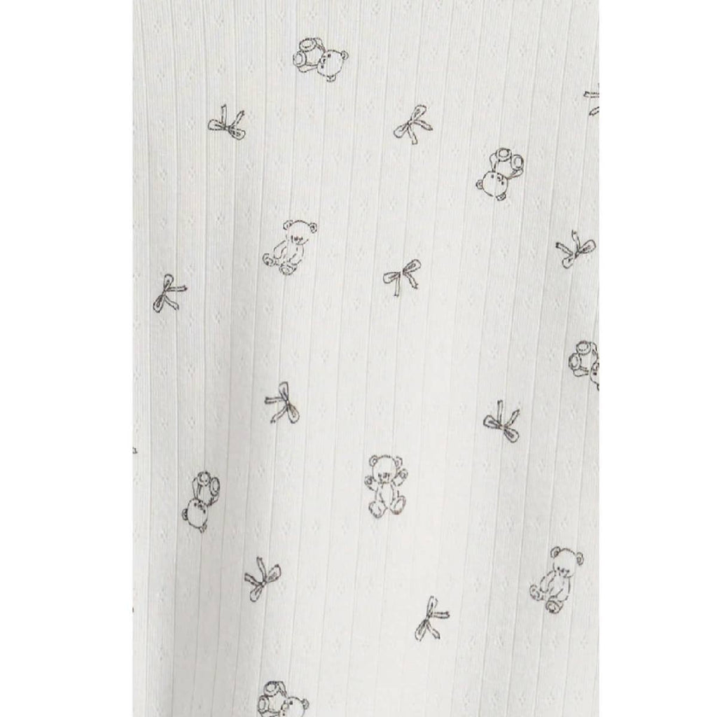 Close-up of the tiny teddy bear and bow print on white pointelle rib knit