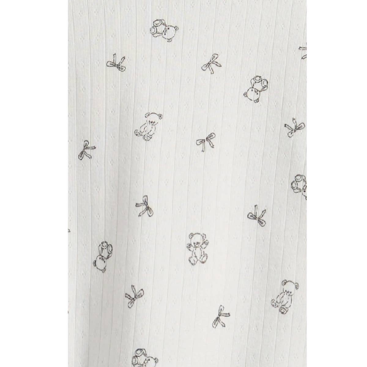 Close-up of the tiny teddy bear and bow print on white pointelle rib knit