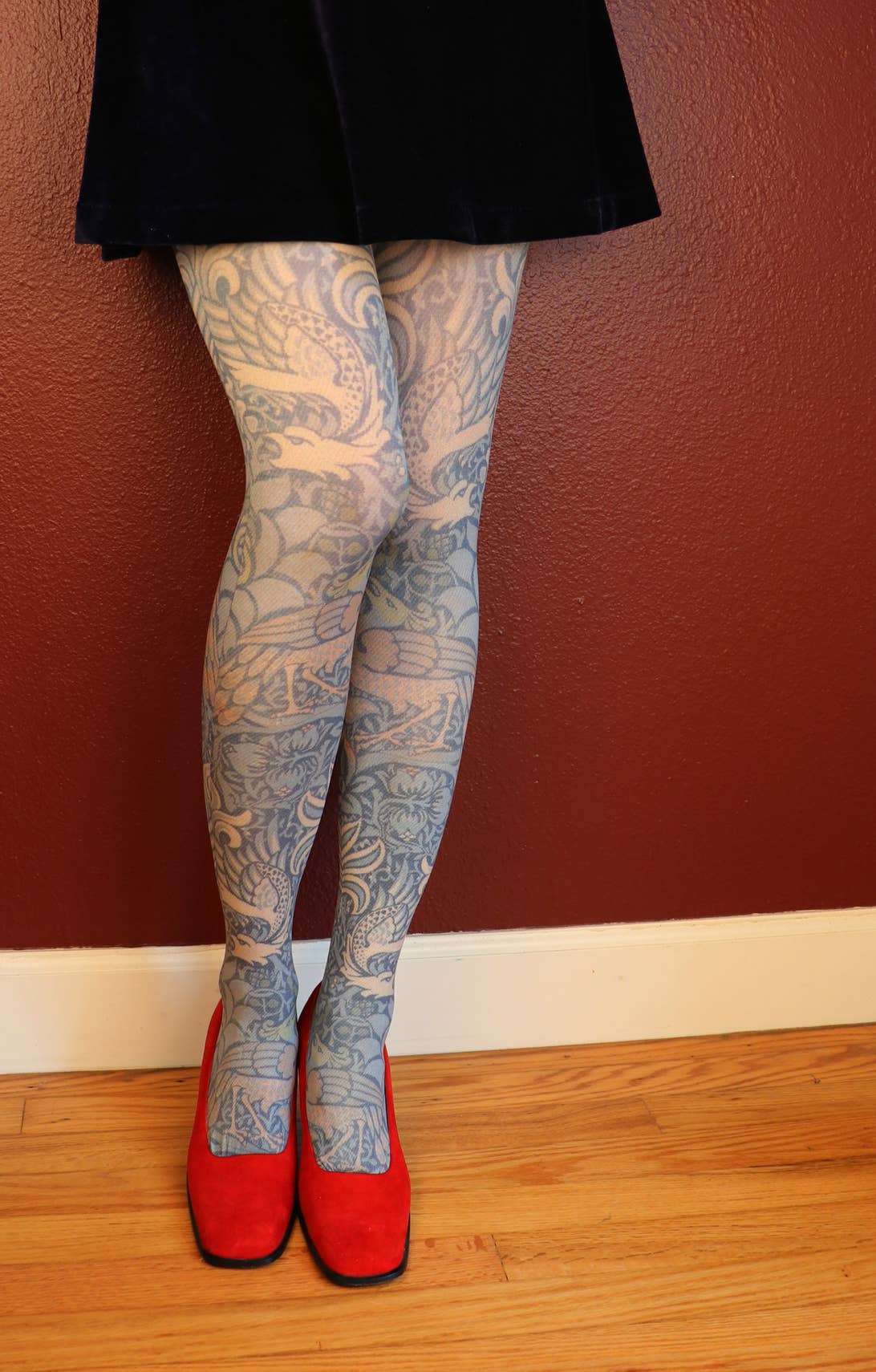 William Morris Peacock and Dragon print tights, on a model with red shoes
