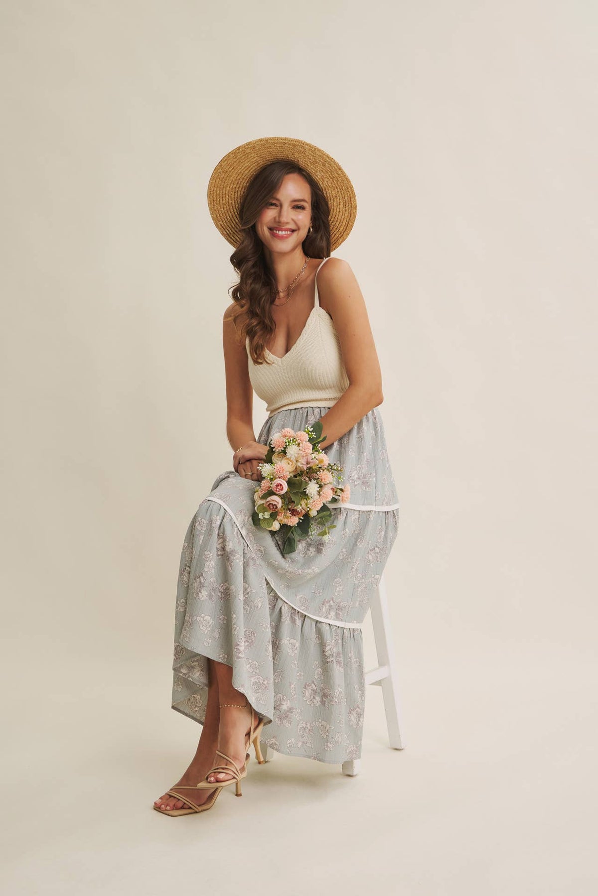 Women's ivory and dusty blue two-fer midi sundress, holding flowers