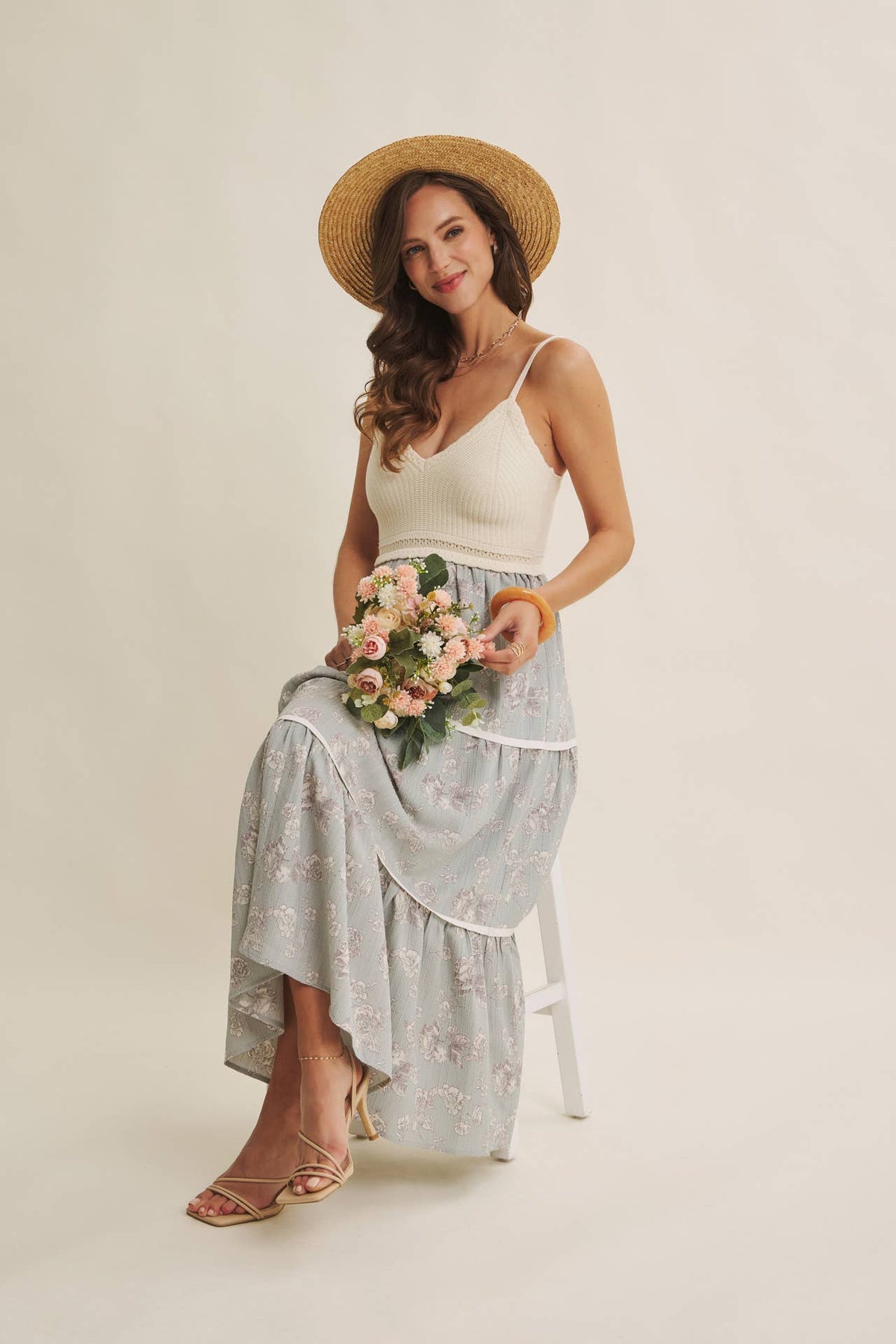 Women's ivory and dusty blue two-fer midi sundress, seated with flowers