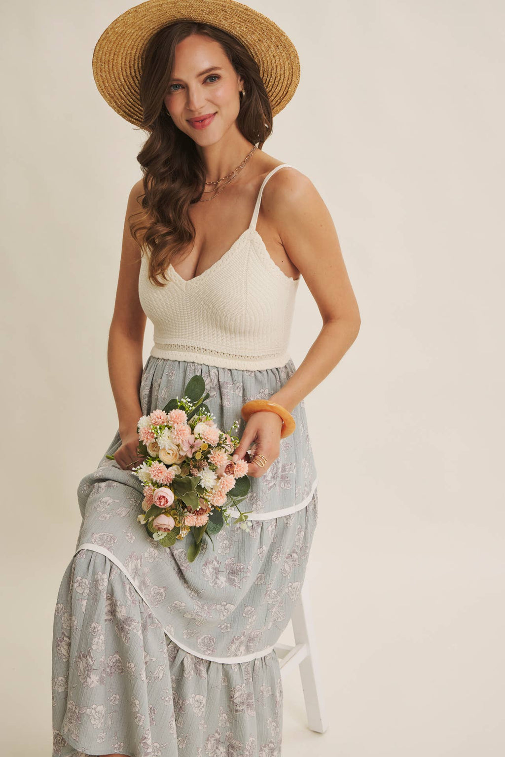 Women's ivory and dusty blue two-fer midi sundress, holding a bouquet