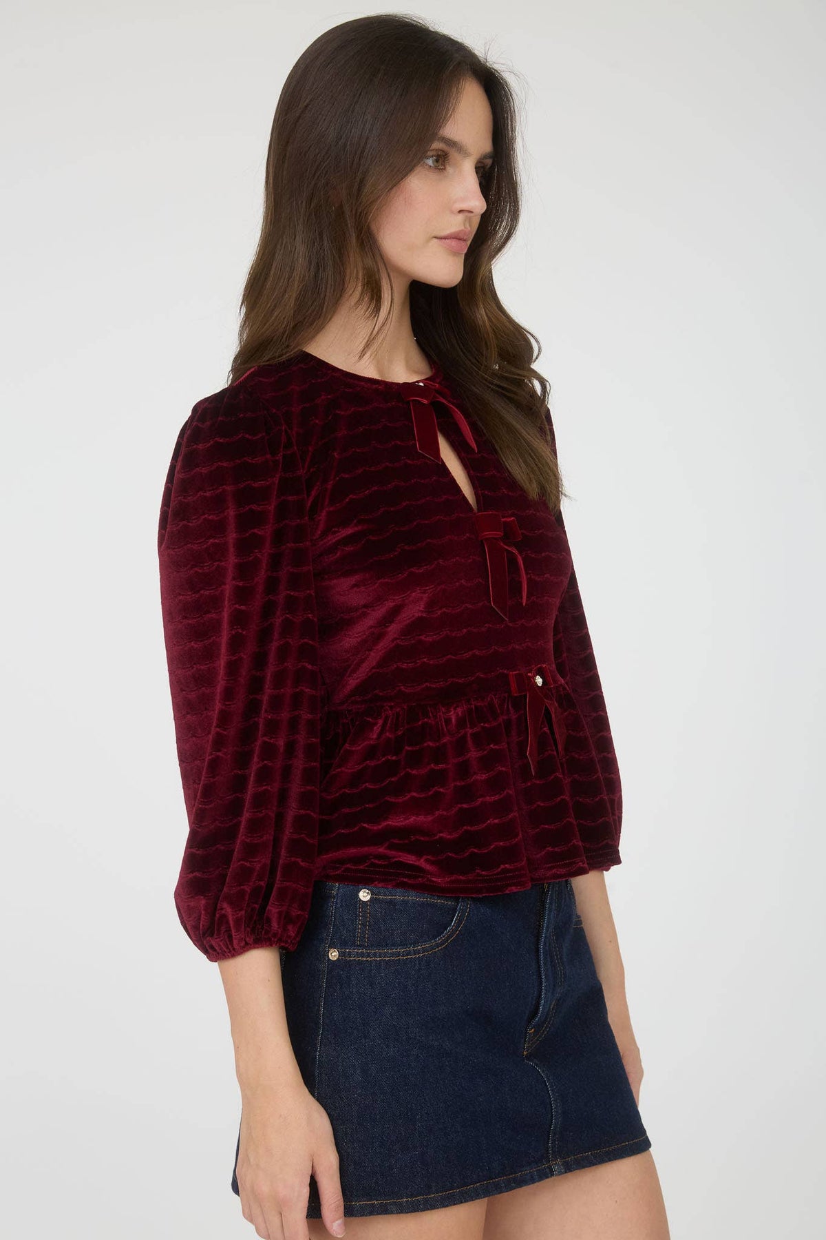 Women's velvet peplum top with pearl buttons, burgundy, side view