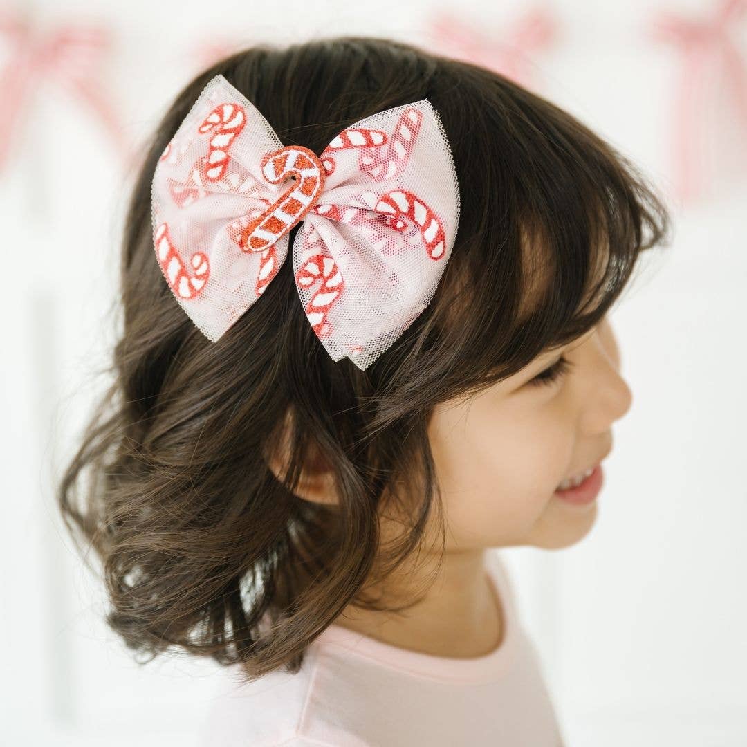 Girl wearing the candy cane tulle hair bow