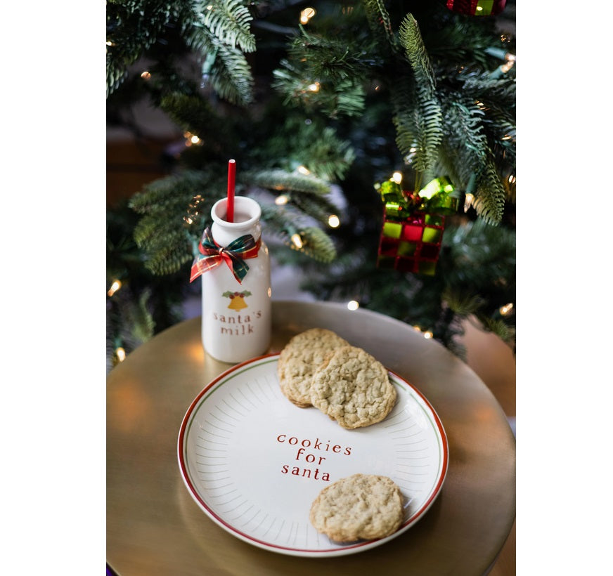 Cookies for Santa plate and milk jug set beside the Christmas tree on Christmas Eve
