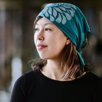 Women's hand-printed jersey bandana, white chrysanthemum teal, worn as head wrap